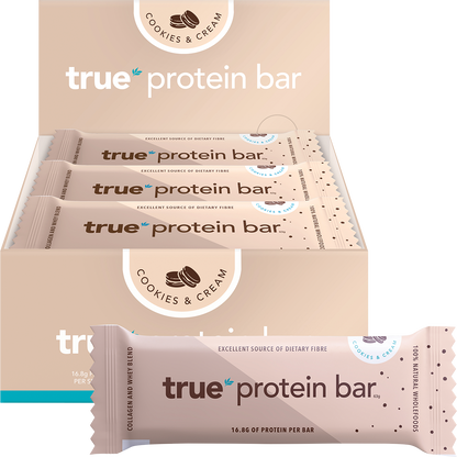 True Protein Cookies & Cream bar and display box on a white background with loose cookies and cream pieces.