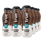 Six bottles of true protein shake arranged in a row on a white background. The bottles are dark brown with black caps and white lower labels, featuring the brand name 'true' and 'Rich Chocolate' text.