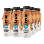Six bottles of true protein powder arranged in a row on a white background. The bottles are filled with a salted caramel flavored protein shake, featuring a peach and white color scheme with black caps.