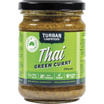 A jar of Turban Chopsticks Thai Green Curry Paste 240g with fresh ingredients like basil, coriander, and lime.