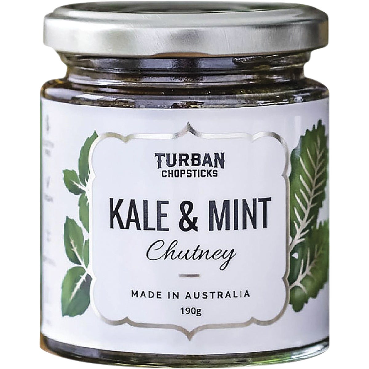 A jar of Turban Chopsticks Kale and Mint Chutney with fresh green ingredients on a white background.