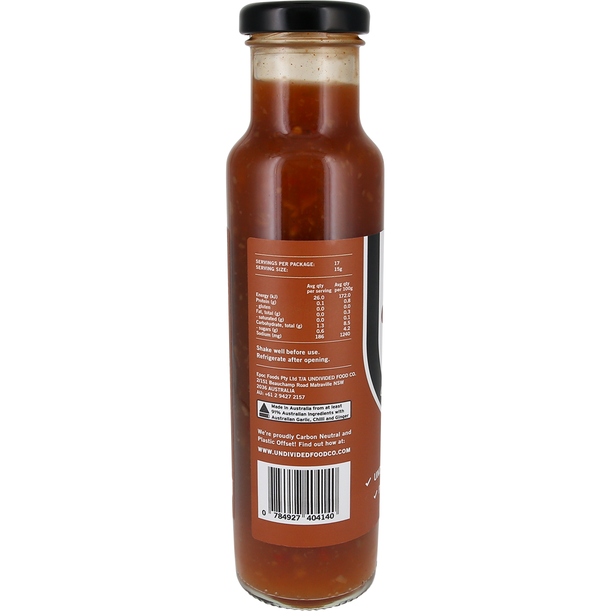 Back view of a glass bottle of sauce with a black lid and a brown label showing nutrition facts and text, on a white background.