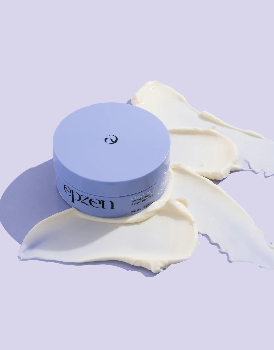 Close-up of thick, white Epzen Body Butter being scooped by a finger from a 150ml purple tub.