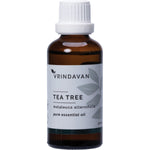 50ml glass bottle of Vrindavan 100% Pure Tea Tree Essential Oil with a black dropper cap and botanical leaf illustrations.