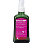 Back of a 100ml Weleda Wild Rose Harmonising Body Oil glass bottle showing ingredients and product information.