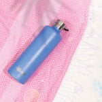 Azure blue 1L Cheeki insulated water bottle with a silver lid and carry handle on a white background.