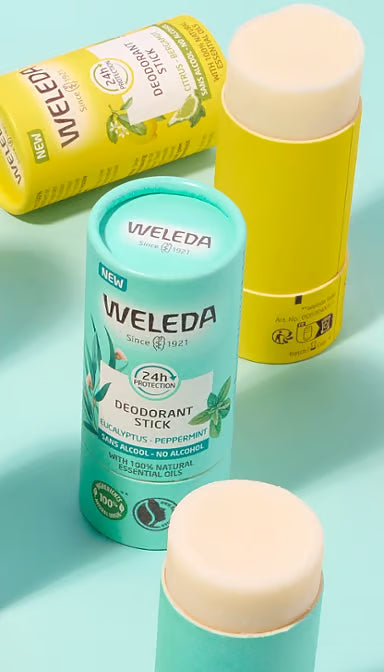 Two open Weleda deodorant sticks, Citrus and Eucalyptus scents, in cardboard tubes on a white background.