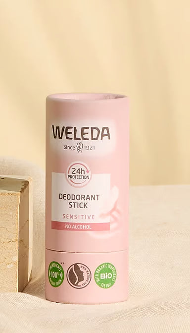 Weleda Sensitive Deodorant Stick with flowers and ingredients on a white background.