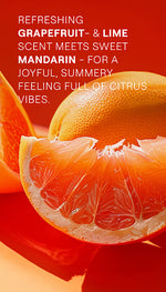Weleda Happiness Grapefruit Shower Gel tube among fresh grapefruit, lime, and orange slices.