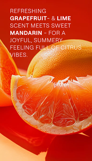 Weleda Happiness Grapefruit Shower Gel tube among fresh grapefruit, lime, and orange slices.