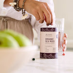 Lifestyle shot of the Evolution Botanicals Organic Sea Moss tube on a neutral surface with a wellness aesthetic.